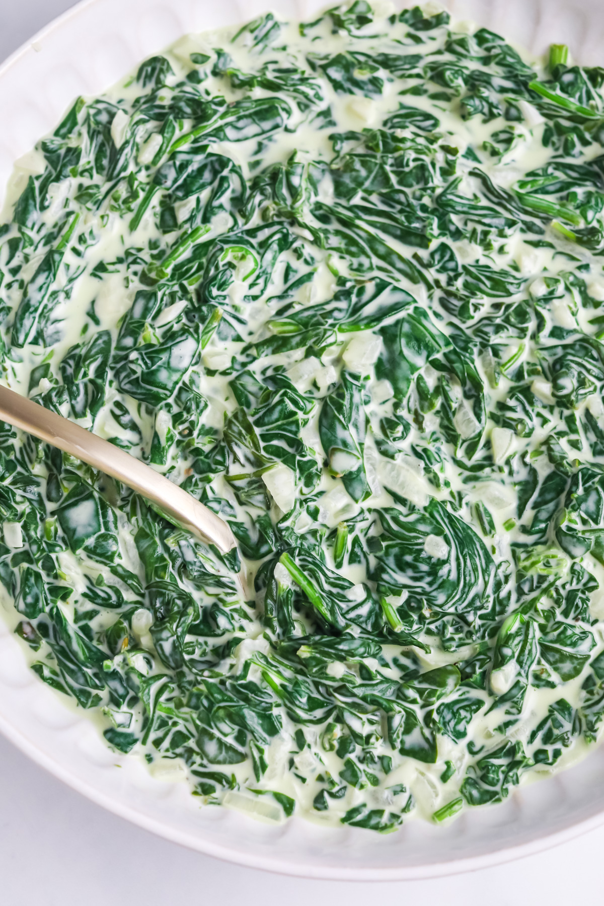 Creamed spinach being served.