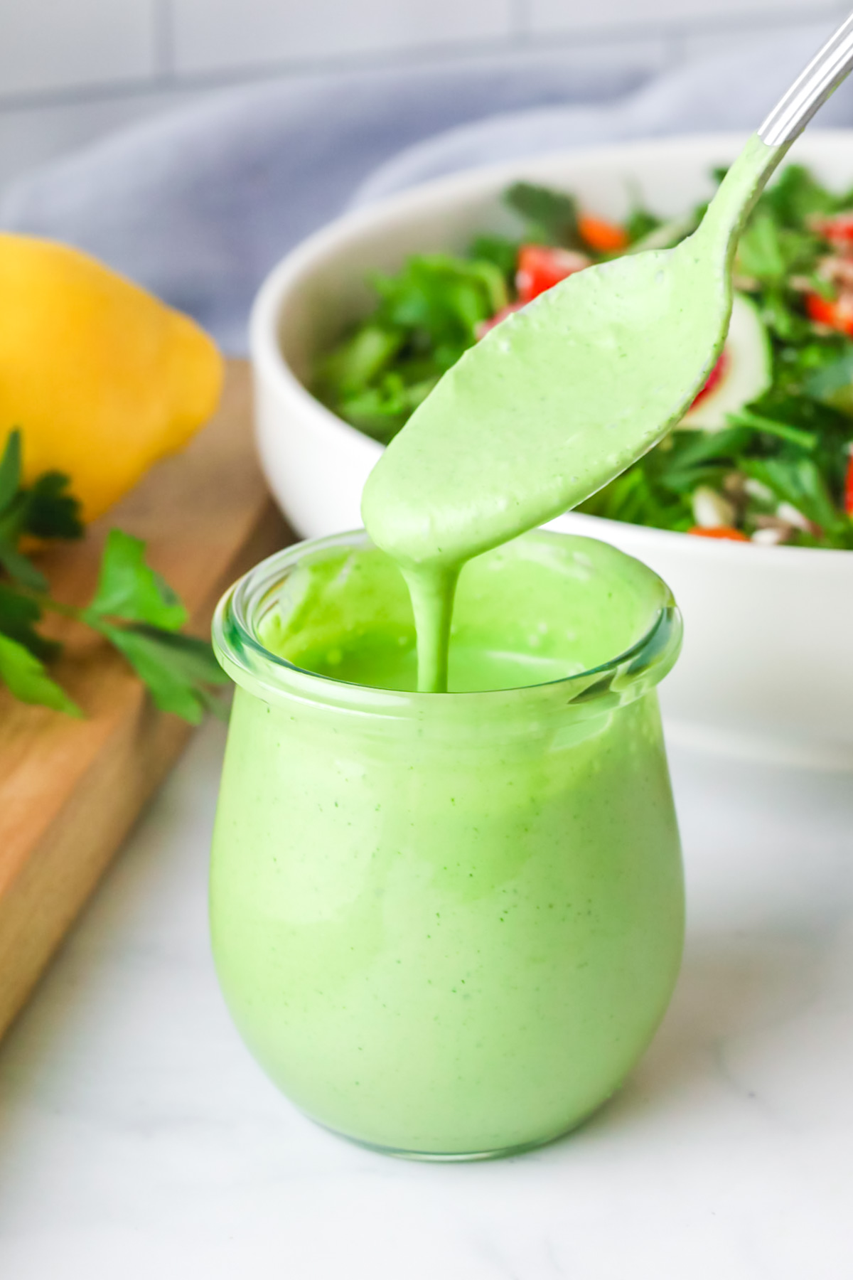 Green goddess dressing with spoon. 